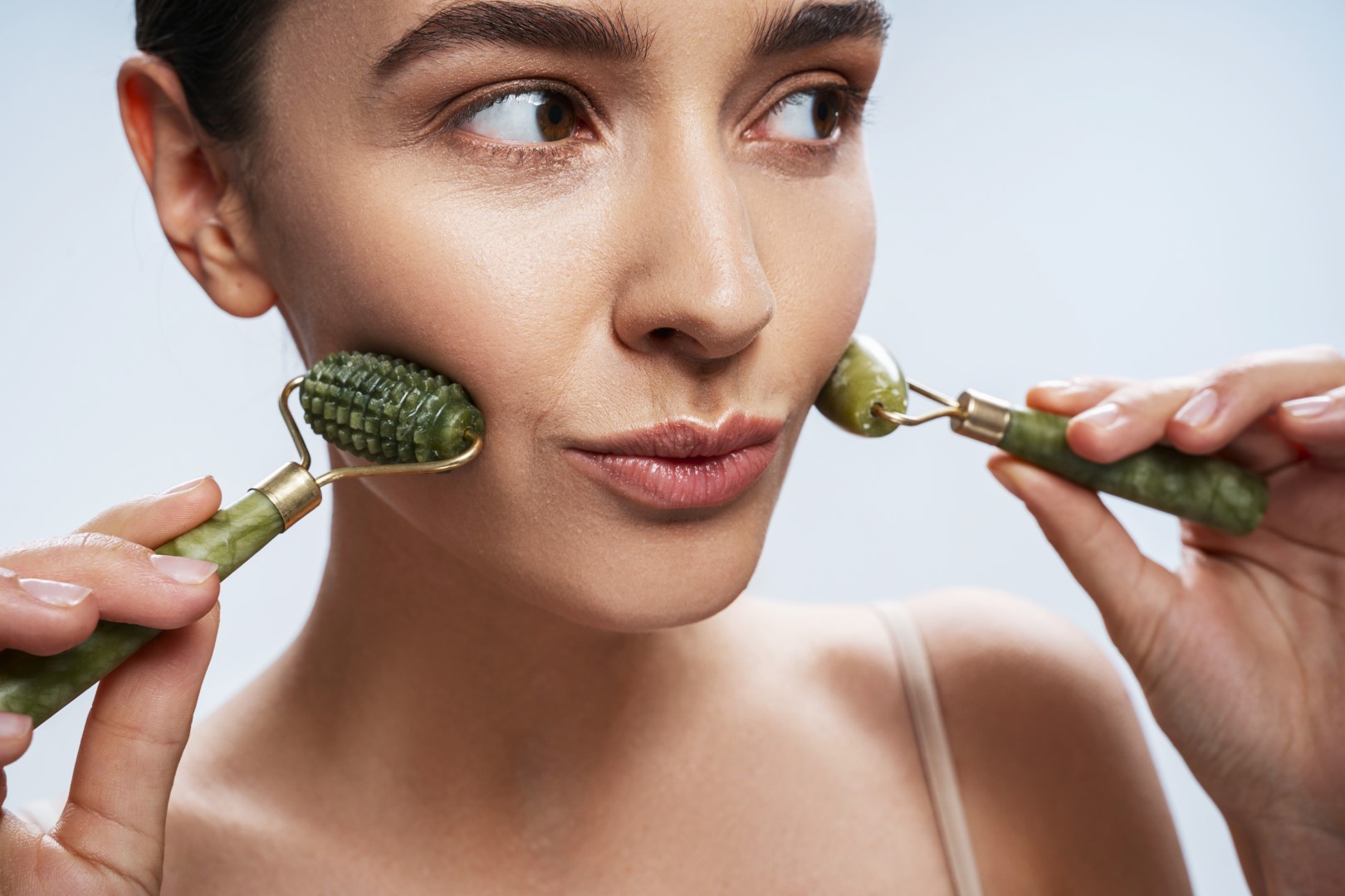 Close,Up,Portrait,Of,A,Lovely,Lady,With,A,Pair of jade rollers