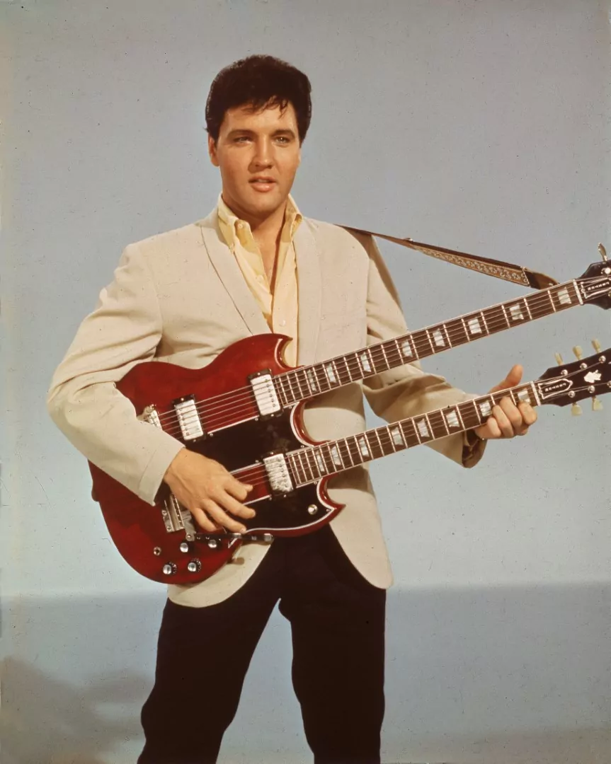 Portrait of American singer and actor Elvis Presley (1935 - 1977) holding a 1965 Gibson EBS-1250 Double Bass (a combined 6-string and bass guitar), circa 1966. Elvis is seen playing the guitar in his 1966 film, 'Spinout'. (Photo by Hulton Archive/Getty Images)