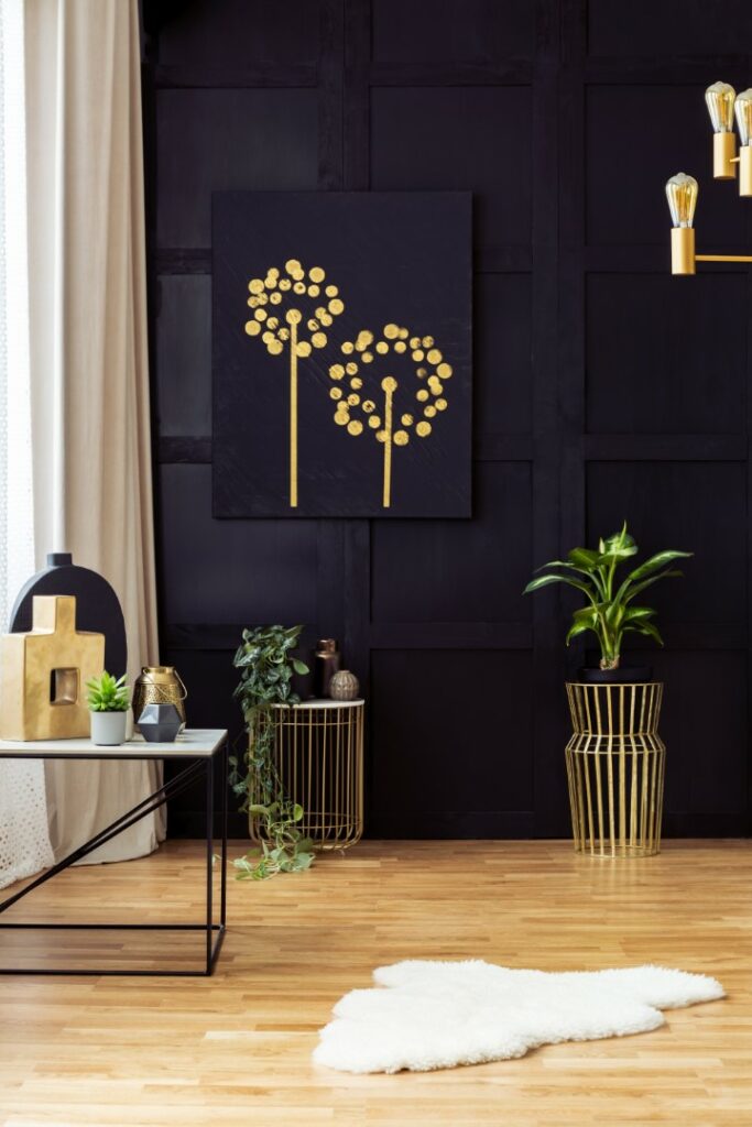 Elegant living room interior with golden accents, painting on a black wall, plants and fur rug. Real photo