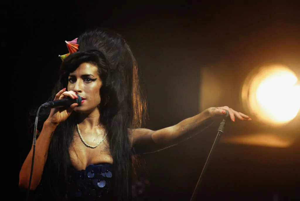GLASTONBURY, UNITED KINGDOM - JUNE 28: Amy Winehouse performs on the Pyramid Stage at the Glastonbury Festival at Worthy Farm, Pilton on June 28 2008 in Glastonbury, Somerset, England. Nearly 175,000 people were expected to be on site for the three-day music festival which started yesterday and features headline acts Kings of Leon, rapper Jay-Z and Britpop veterans The Verve. (Photo by Matt Cardy/Getty Images)
