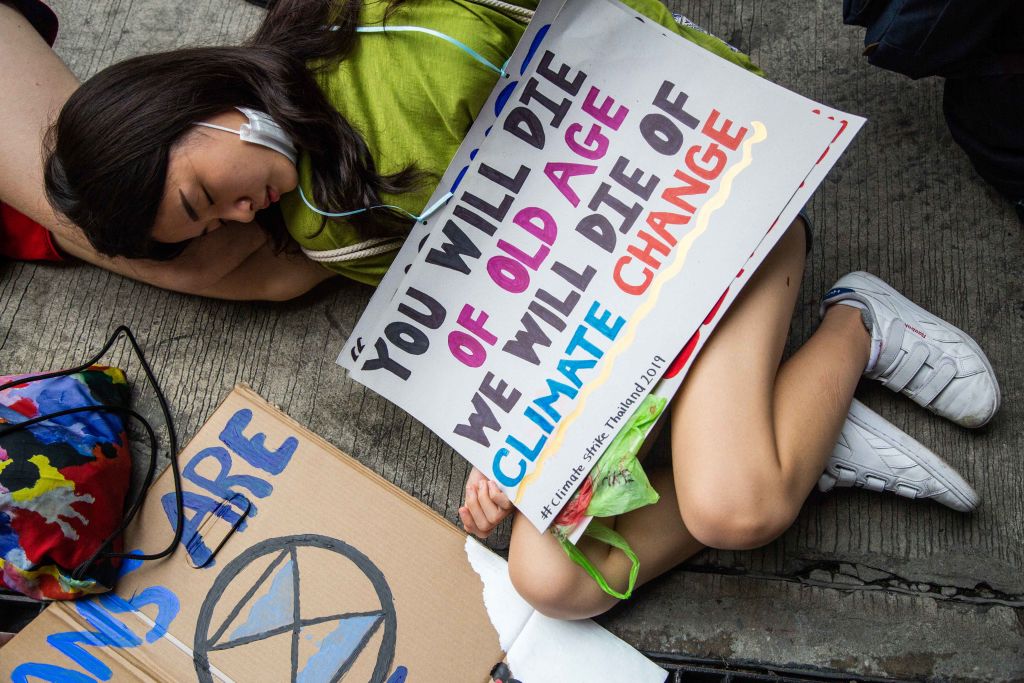 Najtoplije godine ikad izmjerene - mlada žena drži plakat kojim upozorava na klimatsku krizu