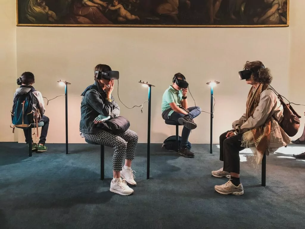 Četiri osobe sjede s VR headsetom