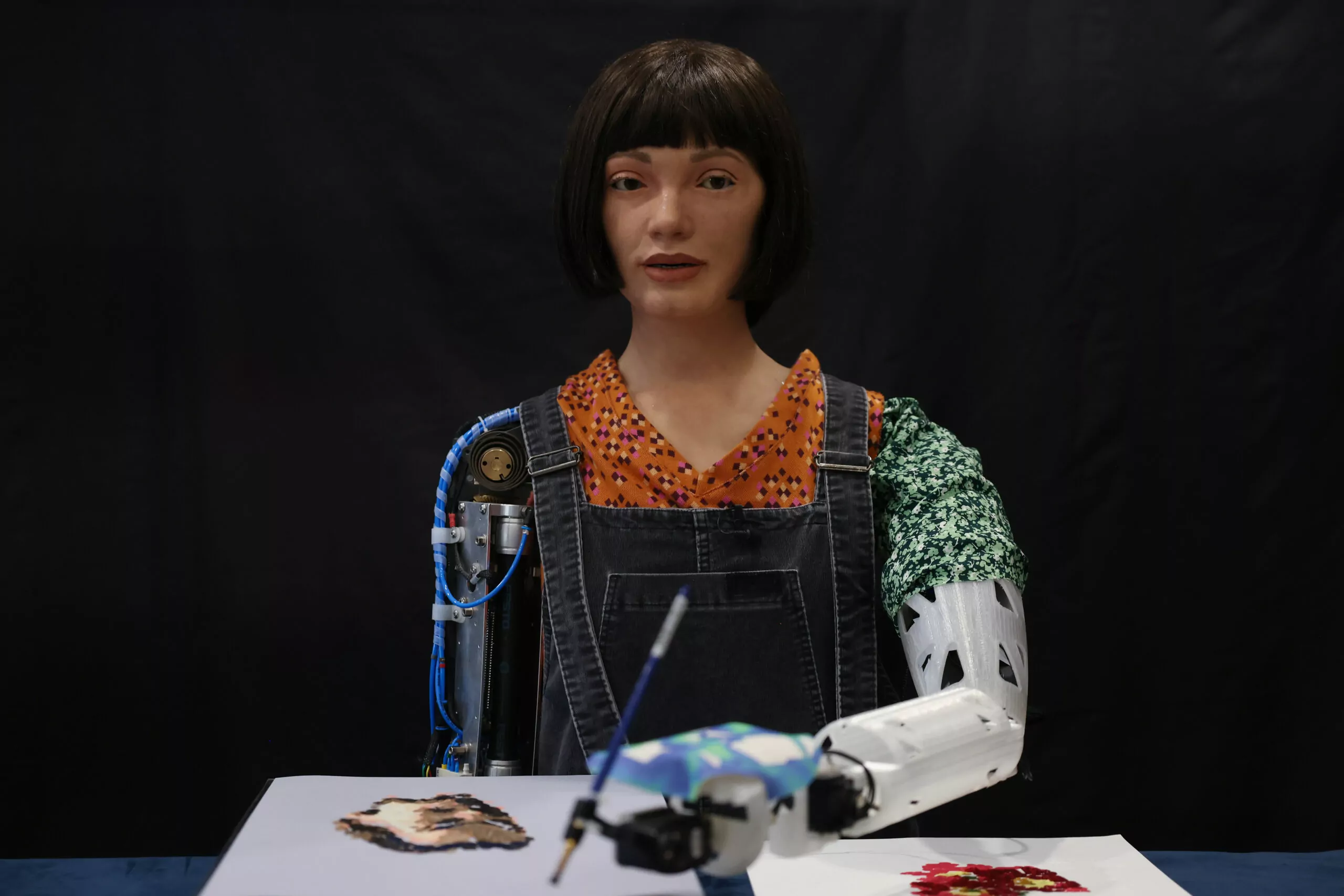 LONDON, ENGLAND - APRIL 04: Ai-Da Robot, an ultra-realistic humanoid robot artist, paints during a press call at The British Library on April 4, 2022 in London, England. Ai-Da will open her solo exhibition LEAPING INTO THE METAVERSE at the Venice Biennale this year curated by Aidan Meller. (Photo by Hollie Adams/Getty Images)