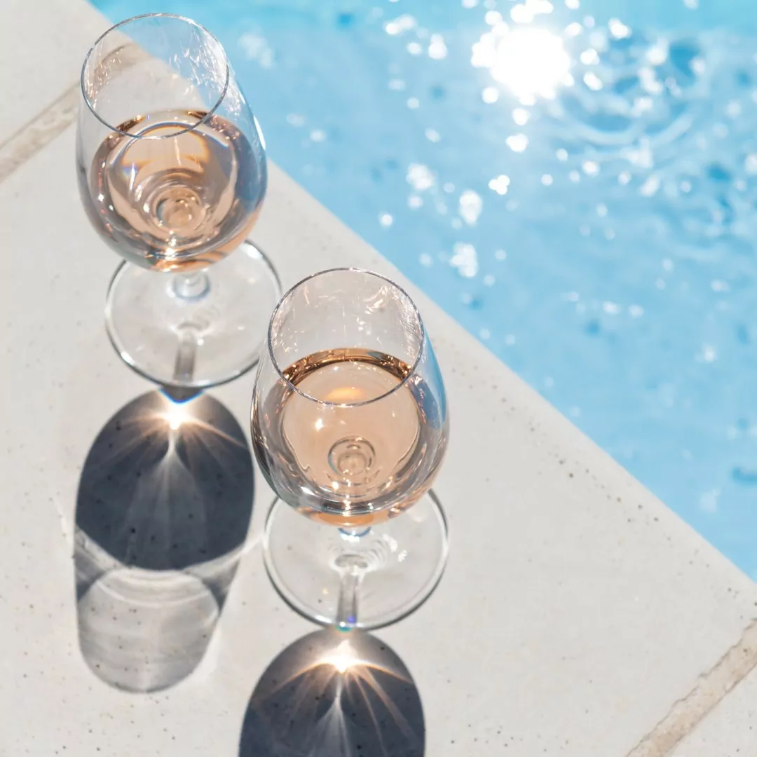 two glasses next to the pool in hard light