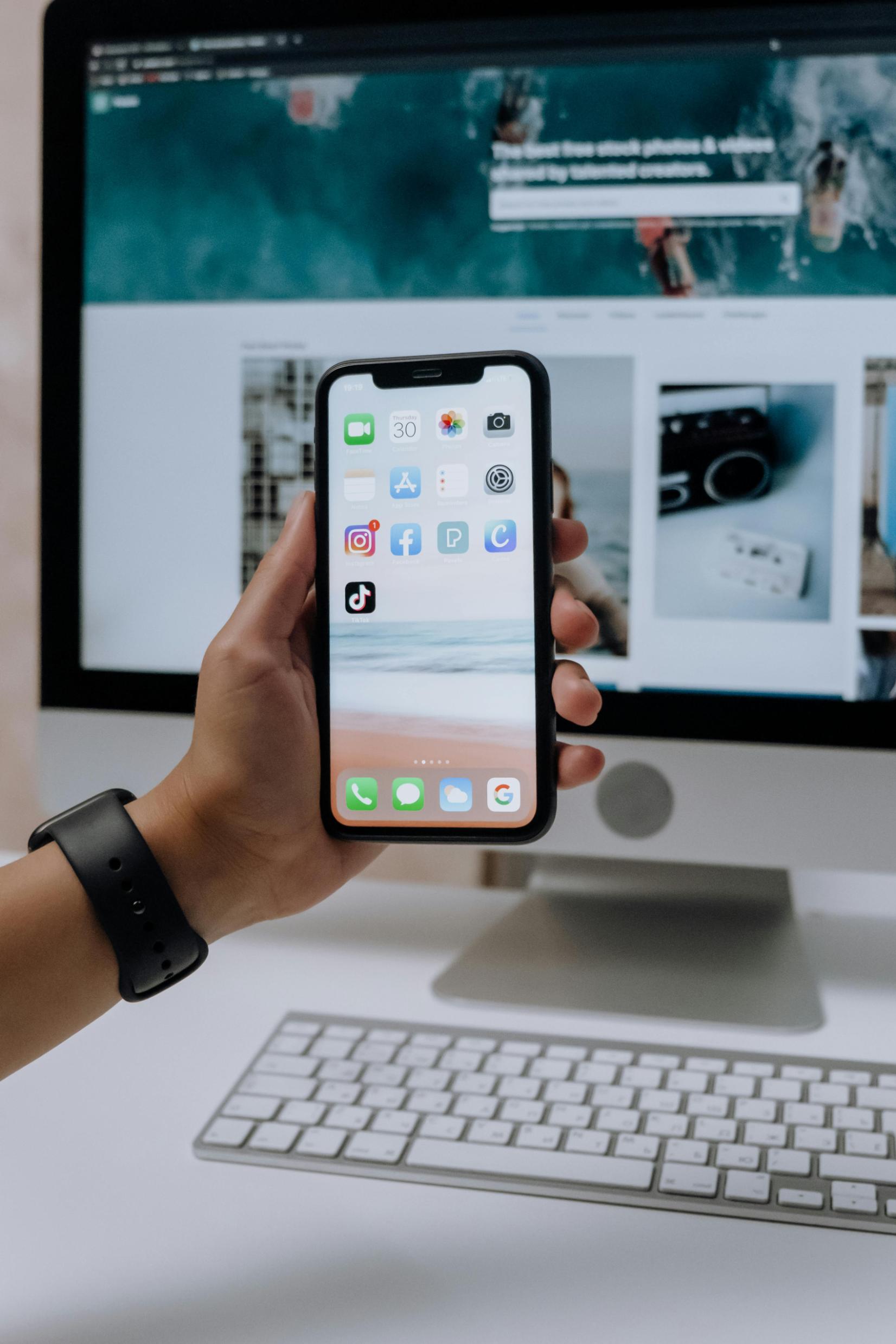 mobitel s aplikackijama ispred ekrana monitora