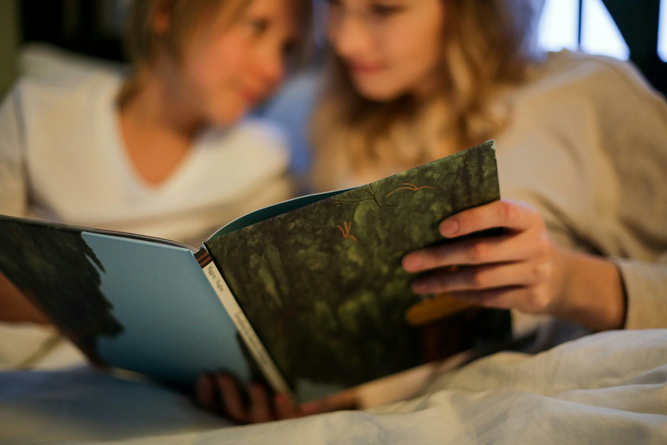 dječji sleepover - dijete i majka čitaju prije spavanja