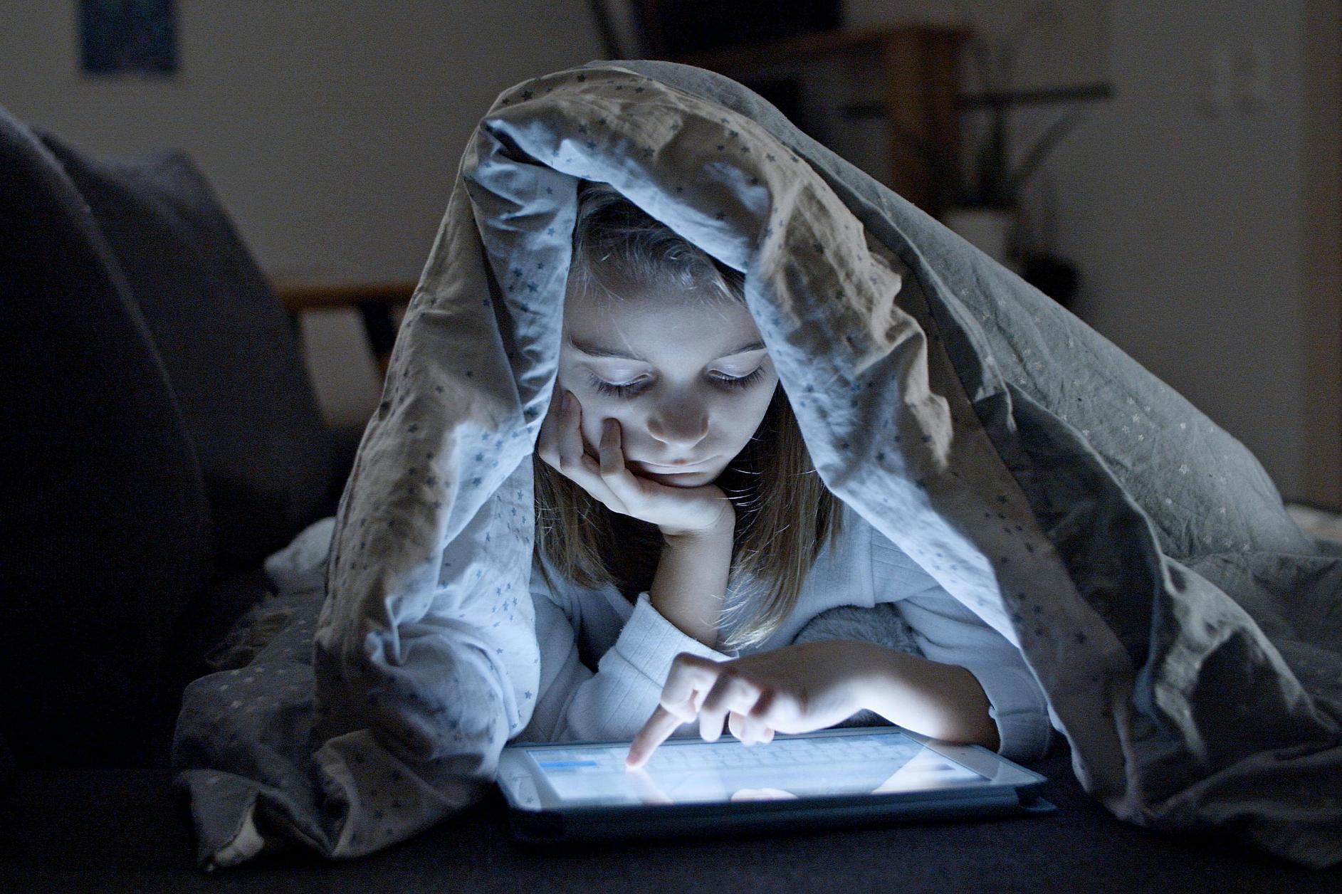 dječji sleepover - dijete koristi mobitel u krevetu